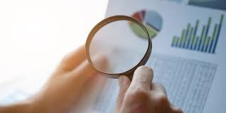 Magnifying glass looking at graphs on a sheet of paper